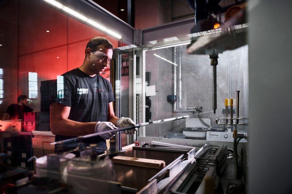 Ein Mann arbeitet an einem Kleberoboter in einer Fabrik